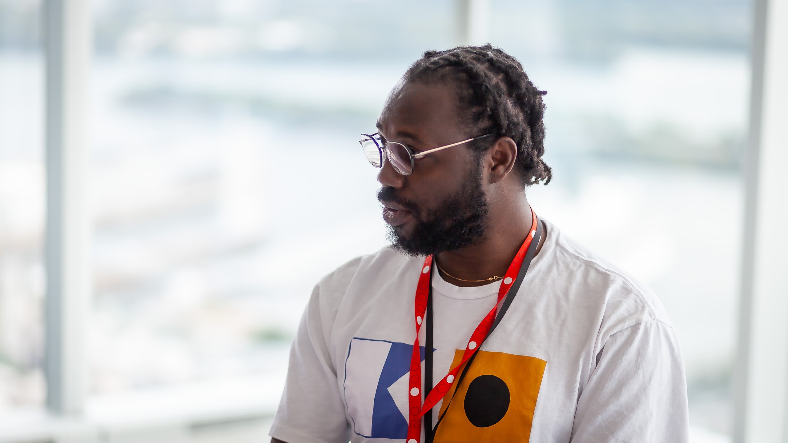 A speaker in profile, wearing glasses and a red lanyard, during the International Selection Panel in Montreal